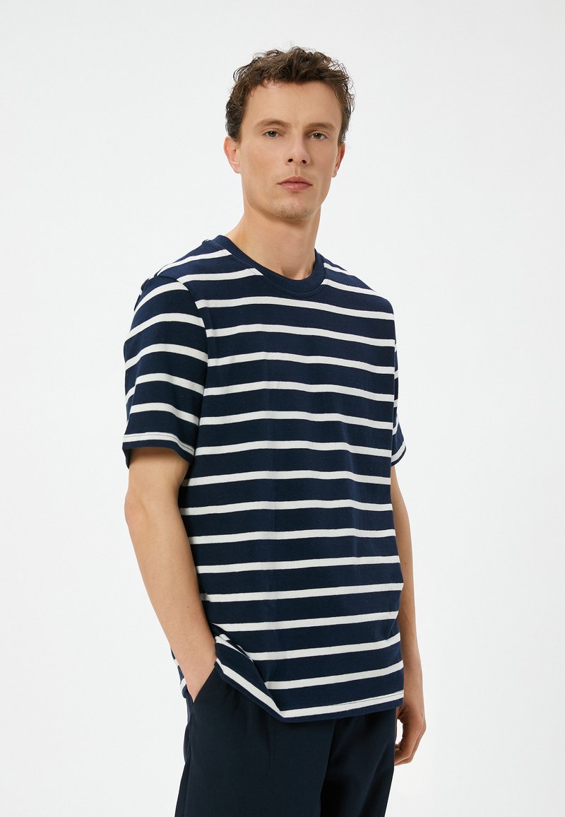 Marineblå og hvid stribet bomulds t-shirt med rund halsudskæring, korte ærmer og sidelæg. Blød tekstur, afslappet pasform.