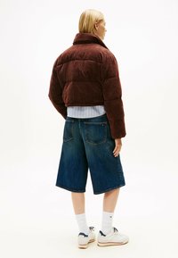 Brun kordfløjl jakke, blåstribet skjorte, denim culottes, hvide sportsokker og hvide sneakers med marineblå accenter.