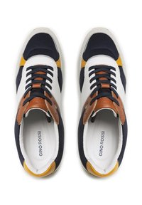 Tumed ja valged sneakers pruunide aktsentidega, millel on võrkkangast ülemine osa, ümar nina, valge kummitald ja nööbitav sulgemine. GINO ROSSI brändimine sees.