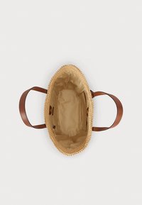 Smeđa torba od slame s kožnom drškom, bež tkaninski unutrašnjost, okrugli oblik i detalji prošivanja duž gornjeg ruba.