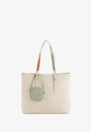 Kremowa torba typu tote z dwukolorowymi przeszywanymi uchwytami oraz małą, okrągłą, zieloną saszetką na zamek i z paskiem na nadgarstek.