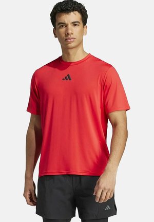 Rode sportieve short-sleeve shirt met een ronde hals en een zwart Adidas-logo op de borst. Glad, lichtgewicht materiaal; gewone pasvorm.