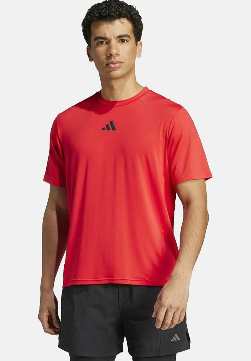 Rotes sportliches Kurzarmshirt mit rundem Halsausschnitt und schwarzem Adidas-Logo auf der Brust. Glattes, leichtes Material; normale Passform.