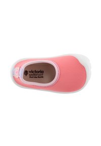 Zapatilla rosa tipo slip-on con parte superior de tela suave y flexible y suela de goma blanca. En el interior presenta una plantilla texturizada con la marca.