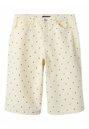 Shorts couleur crème longueur genou avec pois noirs, bouton sur le devant et poches de chaque côté.
