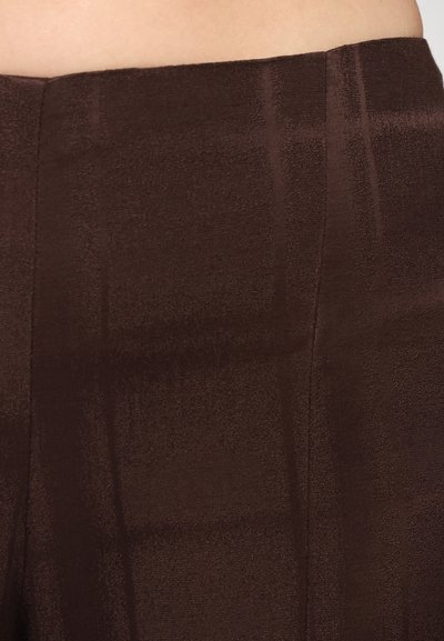 Brown textured fabric with a subtle sheen. Features a smooth waistband and vertical line patterns for added detail.