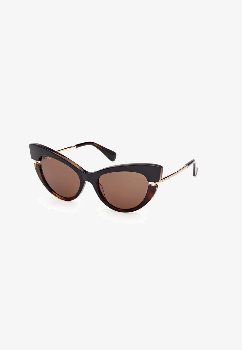 Lunettes de soleil style œil de chat avec des verres brun foncé, des montures écaille de tortue et des branches fines en métal doré sur fond blanc.