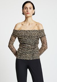 Schulterfreies, halbtransparentes Oberteil mit Leopardenmuster, gerafften Details und langen Ärmeln. Hergestellt aus leichtem, strukturiertem Stoff.