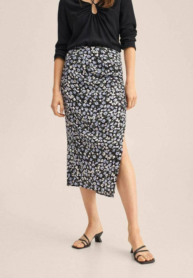 Kukallinen midi-hame mustalla taustalla, vaaleansinisiä ja valkoisia kukkia, sivureikä, istuva malli, yhdistetty mustiin nauhakorkokenkiin.