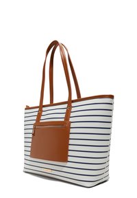 Tote bag with navy stripes on white, featuring brown leather accents and a front zippered pocket. Contains long, sturdy handles.
