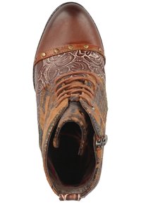 Bruine leren enkelboot met decoratieve metalen studs, ingewikkeld reliëfontwerp en verschillende textuuroppervlakken. Beschikt over veters en een zijrits.