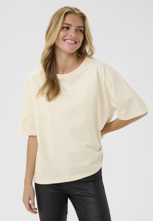 Cremefarvet bomulds t-shirt med rund halsudskæring og korte ærmer, pyntet med små, klare rhinsten spredt over stoffet.