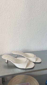 Sandali bianchi con tacco, design aperto con motivo coccodrillo e piccolo tacco a blocco. Texture liscia con un'estetica minimalista.