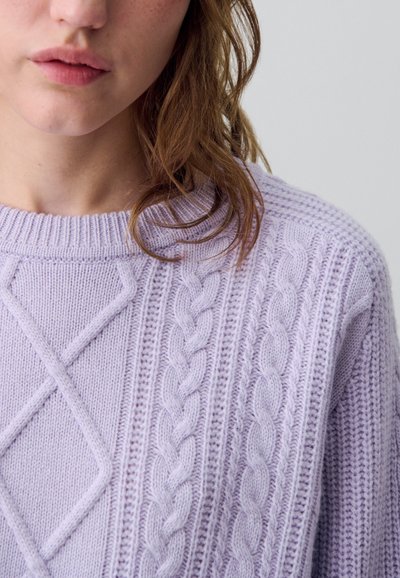 Maglione a maglia lilla chiaro con motivi a treccia e rombi, colletto a coste e texture morbida. Dettaglio ravvicinato del tessuto.