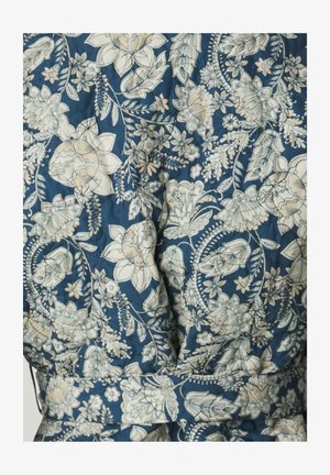 Blomstermønsteret stoff i nyanser av blått og krem, med quiltet tekstur og design med belte i midjen.