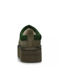 Scarpa platform in camoscio verde con tomaia testurizzata, punta arrotondata e dettagli cuciti. La parte posteriore presenta un anello per facilitare la calzata.