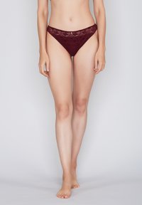 Burgundy lace thong with a floral pattern, featuring a low-rise elastic waistband and smooth fabric, designed for comfort and fit.