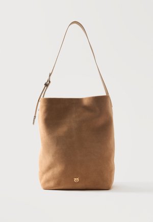 Bolso de hombro de ante marrón suave con una sola correa ajustable y un pequeño logo dorado cerca del centro inferior sobre un fondo blanco.