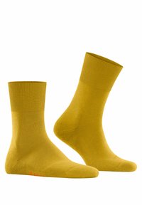 Gelbe Baumwoll-Crew-Socken mit gerippten Bündchen. Glatte Textur und Knöchelhöhe, mit dezentem Logo in Rot an der Zehe.