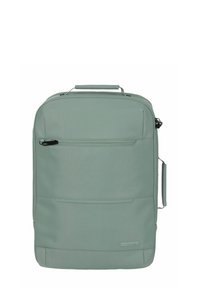 Sac à dos en tissu vert clair avec une poignée supérieure, une poche zippée à l'avant et une texture lisse. Il présente un design minimaliste et un branding subtil.