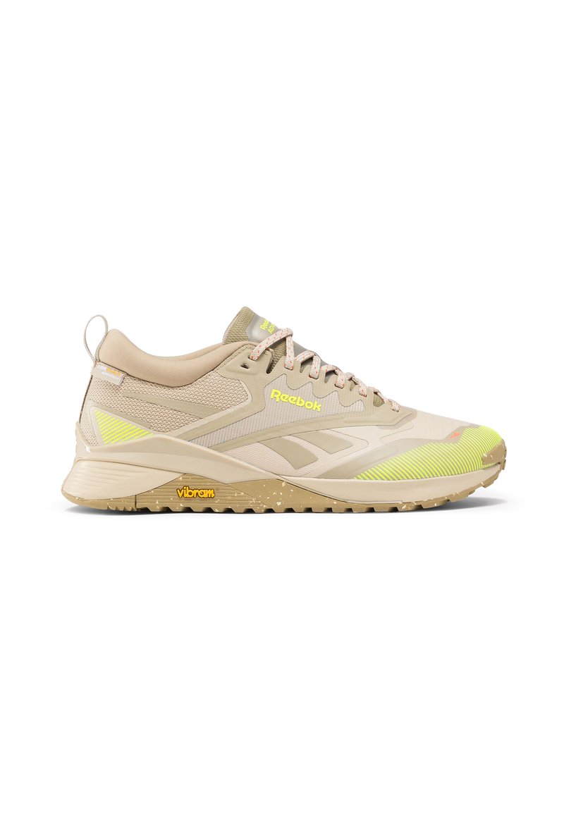 Beige sportcipő, hálós és szintetikus felsőrésszel, világos sárga akcentussal, strapabíró gumi talppal, és Vibram logóval az oldalon.