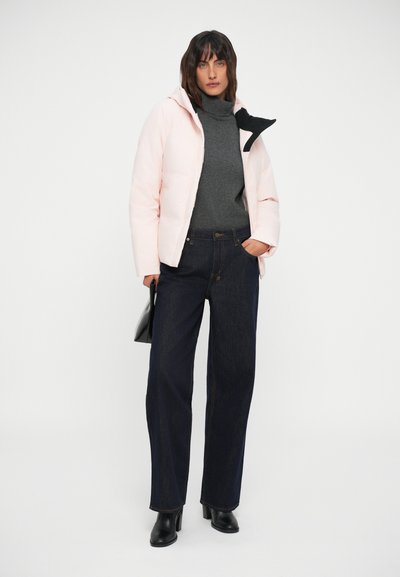 Padded pink jacket with a black collar, grey turtleneck, dark blue wide-leg jeans, and black ankle boots, complementing a black handbag.