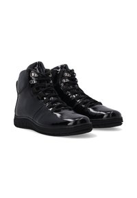 Černé lakované kožené vysoké boty s texturovanými gumovými podrážkami, které mají kovové očky, šňůrky a hladký povrch.