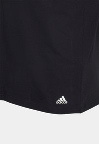 T-shirt in cotone nero con orlo arrotondato e logo Adidas bianco nell'angolo in basso a destra. Design semplice, texture morbida.