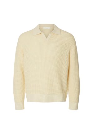 Maglione lavorato a maglia color crema con collo a V con risvolto e polsini e orlo a coste, mostrato su sfondo bianco.