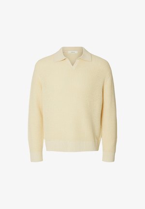 Maglione lavorato a maglia color crema con collo a V con risvolto e polsini e orlo a coste, mostrato su sfondo bianco.