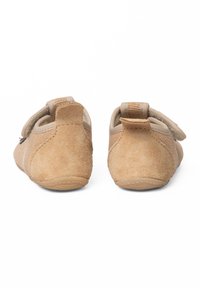 Brązowe zamszowe buty o miękkiej teksturze, z paskiem na rzep. Okrągłe tyły i lekka gumowa podeszwa zapewniająca elastyczność i przyczepność.