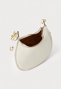Borsa in pelle crema con forma curvata, hardware dorato, chiusura con zip e interno in suede marrone, dotata di una piccola tasca interna.
