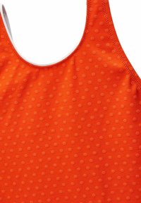 Débardeur orange présentant une texture lisse avec des pois en relief, un col rond et des bretelles fines, conçu pour le confort et l'ajustement.