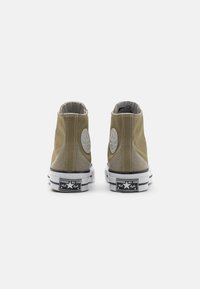 Vysoké tenisky olivově zelené barvy z plátna s šedými akcenty, bílé gumové podrážky a černé logo "Converse All Star" na patě.