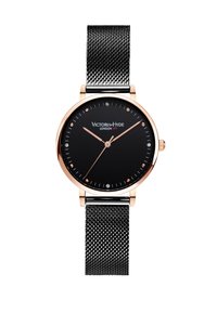 Reloj negro con una caja redonda de oro rosa y correa de malla negra. La esfera presenta acentos dorados y marcadores de cristal. Marca: Victoria-Hyde Londres.