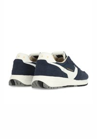Zapatillas de ante azul marino con acentos blancos, que presentan un diseño texturizado, cuello acolchado y suela de goma. Detalle de letra dorada de la marca.