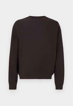 Mørkebrun genser laget av bomullsblanding, med rund hals, ribbestrikkede mansjetter og kant, samt en diskret logo på brystet.