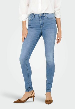 Tynde blå denim jeans med høj talje, med knaplukning, for- og baglommer samt en glat stofoverflade. Båret med brune slingback hæle.