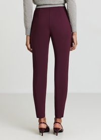 Burgunderfarbene, maßgeschneiderte Hosen mit glatter Textur, mittlerer Taille und schmaler Passform. Stylisch kombiniert mit einem grauen Pullover und passenden High Heels.