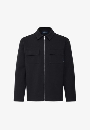 Veste noire à manches longues avec col, fermeture éclair à l'avant et deux poches à rabat sur la poitrine, posée à plat sur un fond blanc.