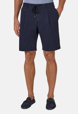Pantaloni da bagno blu navy realizzati in tessuto leggero, con cintura regolabile, pieghe frontali e una texture liscia.
