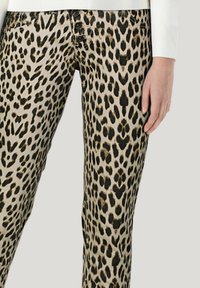 Leopardenmuster-Hosen mit beigem Grund und schwarzen Flecken, fünf Knopfverschluss und Seitentaschen. Glatte Stoffoberfläche.