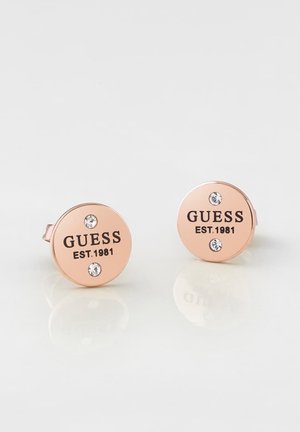 Runde øreringe i rosaguldbelagt stift med to små klare krystaller og "GUESS EST. 1981" indgraveret på hver.