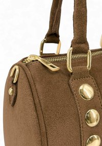 Sac à main en daim marron avec fermeture éclair dorée, boutons ronds dorés et accessoires dorés sur les poignées, sur fond blanc.