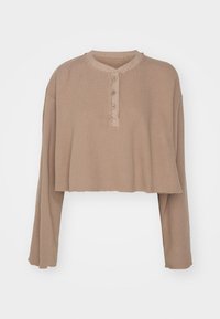 Beige, kurz geschnittenes Langarmoberteil, gerippte Textur, runder Ausschnitt mit Knopfleiste, ausgefranste Kanten und lässige Passform.