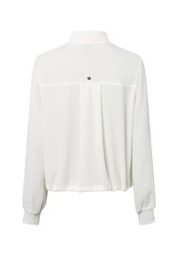 Weiße Bluse mit langen Ärmeln und hohem Kragen, elastischem Taillenbund und einem kleinen schwarzen Logo, das zentriert unter der oberen Rückennaht platziert ist.