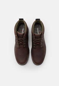 Bottines en cuir marron avec doublure verte contrastante, bout rond, lacets et semelle texturée. Présente le lettrage de la marque sur les semelles intérieures.