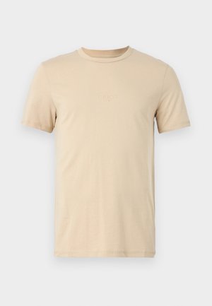 Beige bomull t-skjorte med korte ermer, rund hals og preget LOGO-tekst på forsiden. Glatt tekstur og standard passform.