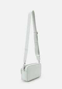 Borsa a tracolla rettangolare in pelle verde menta con tracolla con logo impresso, hardware in argento e chiusura a zip, con una texture liscia.