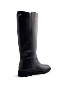 Botas de cuero negras hasta la rodilla con un acabado suave, punta redonda, suela plana y un detalle minimalista de marca dorada en el lateral.